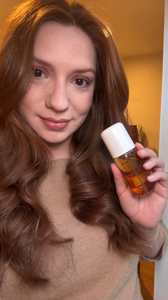 Allure social director Kassidy Silva with a bottle of the Phlur Vanilla Skin Hair Body Mist